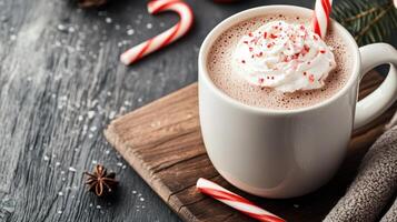 A hot chocolate with whipped cream and candy canes photo