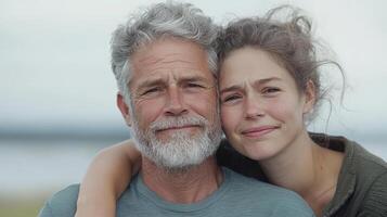 An older man and young woman hugging each other photo
