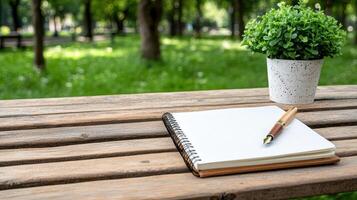 A notebook and pen on a wooden bench in a park photo