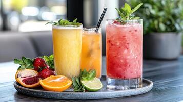 Three different drinks on a tray with fruit and mint leaves photo