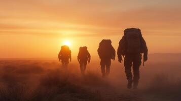 A group of people with backpacks walking in the desert photo
