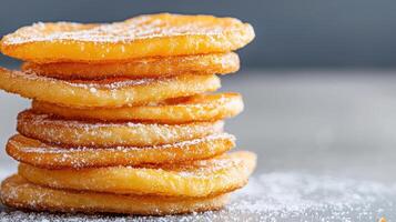 A stack of sugar coated doughnuts on a table photo