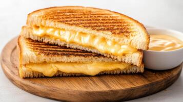 Grilled cheese sandwich with cheese and mustard sauce on a wooden plate photo