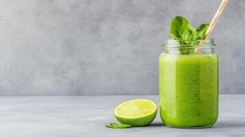 Green smoothie with lime and basil on grey background photo