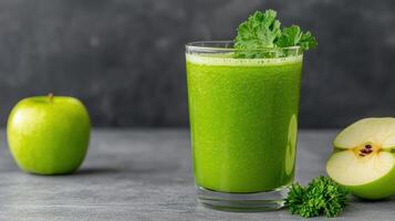 A glass of green juice with an apple and kale photo