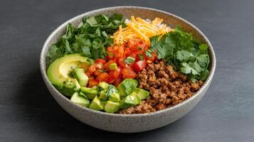 A bowl filled with meat, vegetables and cheese photo