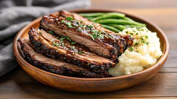 Bbq ribs in a wooden bowl with mashed potatoes and green beans photo