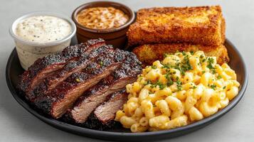 A plate with meat, macaroni and cheese, and bread photo