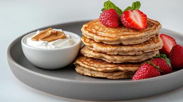 A stack of pancakes with strawberries and whipped cream photo