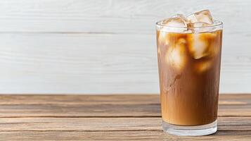 An iced coffee with ice on top of a wooden table photo