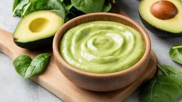 Avocado dip with spinach and avocado on a wooden board photo