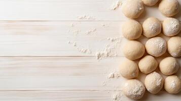 Dough balls on a wooden table with flour photo