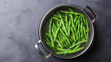 Green beans in a colander on a dark background photo