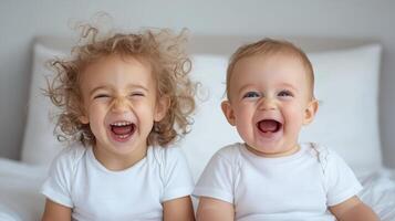 Two young children laughing on a bed photo