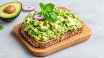 Avocado toast with avocado, onion and basil on a wooden board photo