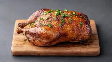 A roasted chicken on a wooden cutting board photo