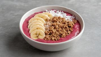 A bowl of smoothie with bananas, coconut and granola photo