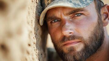 A man in a military uniform is leaning against a wall photo