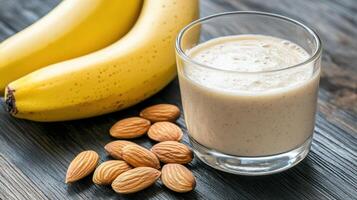 Almond milk smoothie with bananas and almonds on a wooden table photo