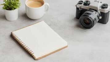 A notebook, coffee and a camera on a gray background photo