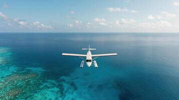 A small plane flying over the ocean with blue water photo