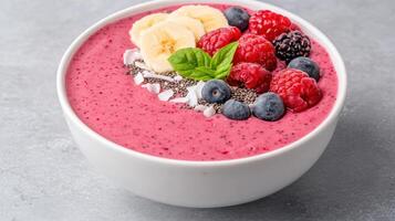 A bowl of smoothie with berries, bananas and other fruits photo