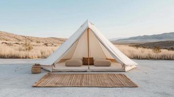 A tent in the desert with a rug and pillows photo