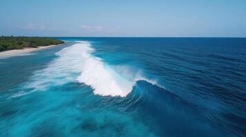 An aerial view of a wave breaking on the beach photo