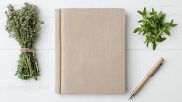A notebook, pen and herbs on a white table photo