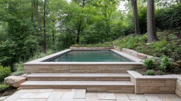 A pool surrounded by stone steps and trees photo