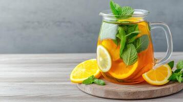 A pitcher of lemonade with mint leaves and oranges photo