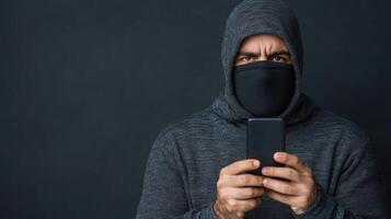 A man in a hoodie is holding a cell phone photo