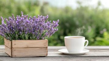Lavender flowers in a wooden box on a wooden table with a cup of tea photo