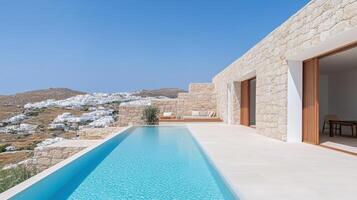 Modern villa with stunning pool and scenic views of white buildings on hillside photo
