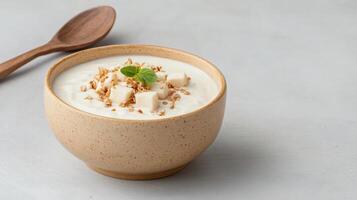 Yogurt with granola and a spoon on a gray background photo