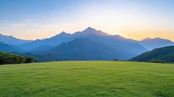 Green grass and mountains at sunset photo