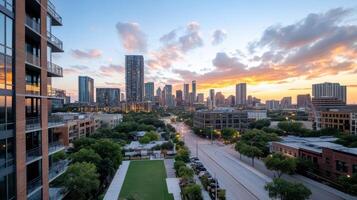 A city skyline at sunset with a green field and buildings photo