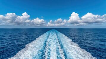 Vibrant ocean waves create stunning contrast against clear blue sky with fluffy clouds photo