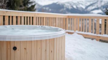 A hot tub on a wooden deck with snow on the ground photo