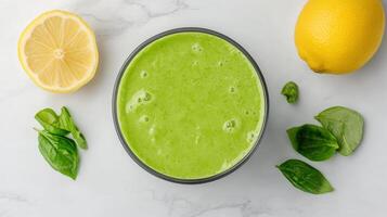 A bowl of green smoothie with lemons and spinach photo