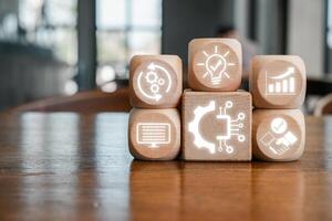 Wooden blocks with digital icons symbolize automation, technology, and modern business solutions on a wooden table. photo