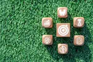 Wooden blocks with strategy icons on grass, symbolizing business planning, innovation, and success. photo