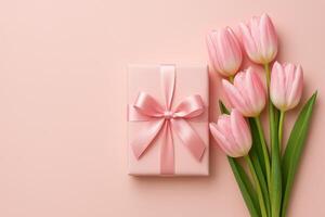 Beautiful Pink Gift Box With Ribbon and Fresh Tulips on Soft Background photo