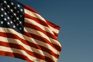 American Flag Waving Proudly Against a Clear Blue Sky With No Obstacles in Sight photo