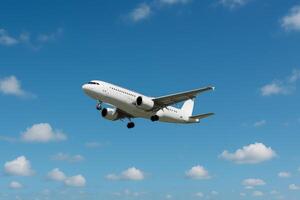 Airplane Flying Against a Blue Sky With Fluffy Clouds During Daylight Hours photo