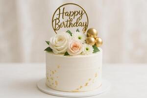 Beautiful White Birthday Cake Decorated With Flowers and a Golden Happy Birthday Topper photo