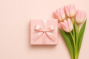 Delicate Gift Box With Pink Ribbon Beside Fresh Tulips on Pastel Background photo