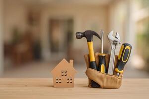 Home Repair Tools Displayed With a Wooden House Model in a Cozy Indoor Setting photo