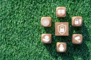 Wooden blocks with privacy icons on grass, symbolizing data security and personal information protection. photo
