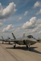 Military Aircraft Ready for Takeoff Under a Cloudy Sky at an Airbase photo